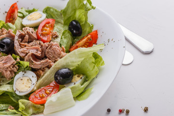 Fresh salad with iceberg lettuce,tomatoes,eggs,canned tuna and olives