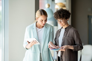 Two young creative designers discussing and choosing colors from palette