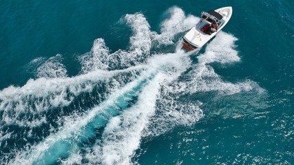Aerial bird's eye view photo taken by drone of boat cruising in Caribbean tropical beach with...