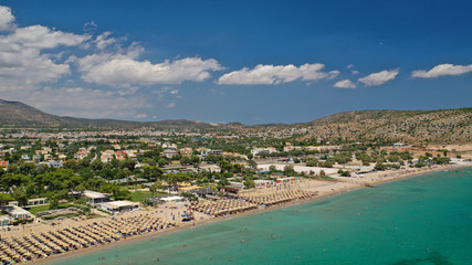 Aerial drone photo of famous seaside village of Varkiza with deep turquoise sandy beaches and clear blue sky, Athens riviera, Attica, Greece