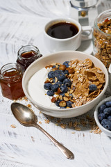 bowl of healthy wholegrain flakes, natural yogurt and fresh blueberries for breakfast, vertical