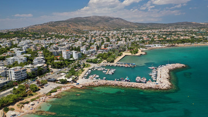 Obraz premium Aerial drone photo of famous seaside village of Varkiza with deep turquoise sandy beaches and clear blue sky, Athens riviera, Attica, Greece