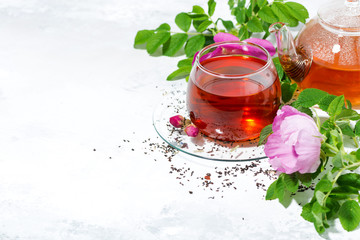 fragrant tea with wild rose in a glass cup and white background