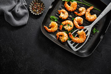 Grilled shrimps on pan on dark background