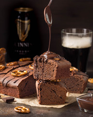 Chocolate brownie on dark beer with salted pretzels and chocolate. Delicious brutal dessert for...