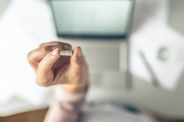 Top view. Tired business woman  holding a headache pill on the workplace with glass of water on the background of graphics and charts printed on the paper.