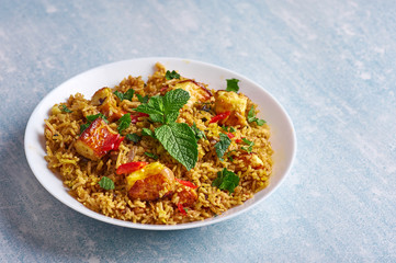 vegetarian paneer biryani at blue background. paneer biryani is traditional veg indian cuisine dish with paneer, basmati rice, masala, chili, mint. Copy space