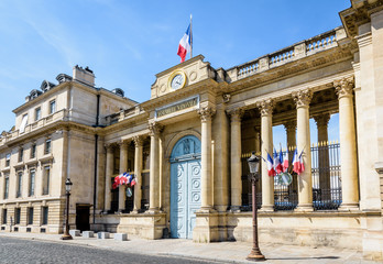 Fototapeta na wymiar Southern entrance of the Palais Bourbon, seat of the French National Assembly in Paris, France, decked with french flags on a sunny summer day.