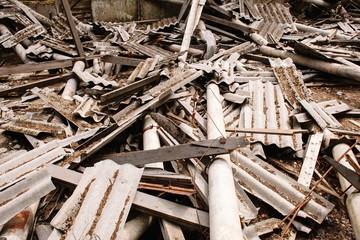 Dilapidated building with reinforced concrete columns and broken slate.