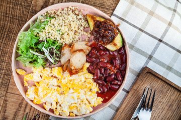 Top view food flat lay. Modern cuisine traditional english breakfast with copy space. Restaurant food. bulgur, green salad, beans, avocado, caramelized onion, omelette, chicken on plate. Copy space