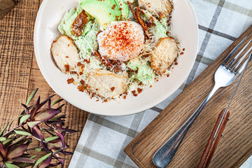 Top view on salad bowl. Healthy food overhead shot. poached egg, green salad, parmesan, avocado and chicken in bowl. Diteing, balanced food for breakfast. Reastaurant food background