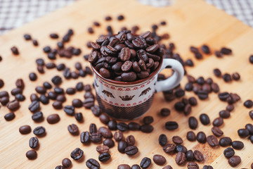 The dark roasted coffee bean in cup