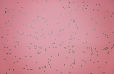Silver sparkles on pink pastel trendy background. Festive backdrop for your projects.