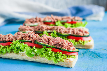 open sandwiches with crispbread slice lettuce cucumber tomato tuna on blue wooden table.healthy snack