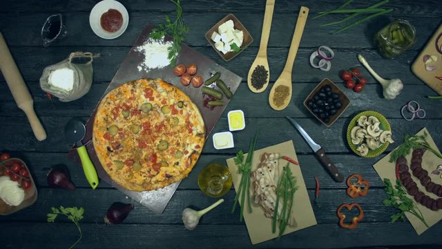 Cheeseburger pizza on ecological black background.  Big pizza is on eco black table. Pizza consists of ingredients: cucumbers, spices, tomatoes, meat, chicken, sauce, cheese.