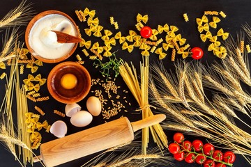 Home made traditional pasta. Flour grain egg pasta on black background. Home cooking food.