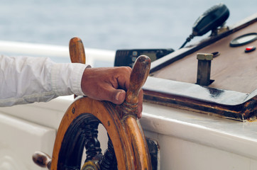 Hands of the captain holding the wheel on the deck of the ship © andrei310