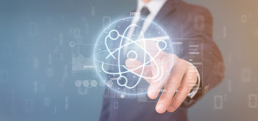 Businessman holding an atom icon surrounded by data