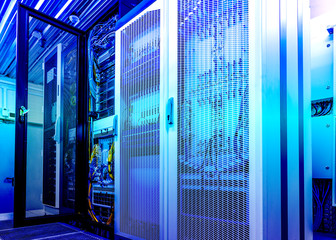 Technical wall of cellular data terminal rows with opened mesh door. modern data center blue toning