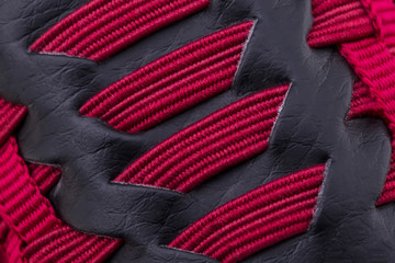 Fragment of red black sneaker fabric. The texture of the material of sports shoes