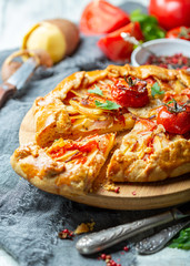 Piece of cake with potatoes, bacon and tomatoes.