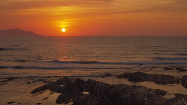 Sun in red sky falls on the marine horizon