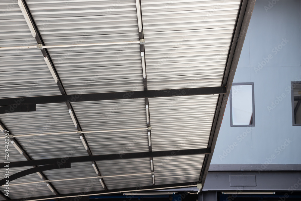 Wall mural silver metal roof of small car park. grey steel roofing.