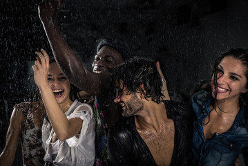 Group of friends dancing in the rain