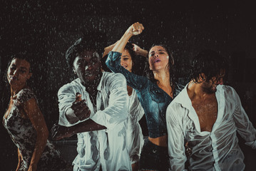 Group of friends dancing in the rain