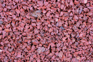 Red rubber covering of a sports ground for children. Texture granule structure background. Sports...