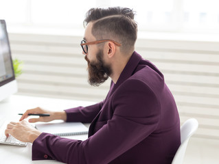 People and technology concept - Side view portrait of handsome man dressed in purple jacket working on at the computer