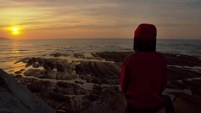 Woman admires beautiful coastal sunset