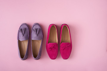 Two pairs of suede moccasins shoes lilac and raspberry over pink background