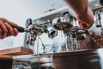 Close up of filter holder and coffee outlet with drops of water