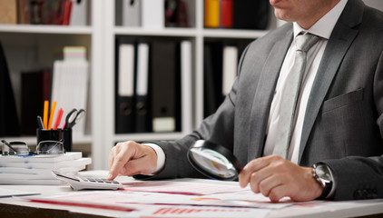 Businessman working and calculating, reads and writes reports. Office employee, table closeup. Business financial accounting concept.