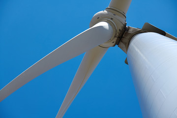 Electricity wind generator on bright cloudy sky background - wind energy and technology concept