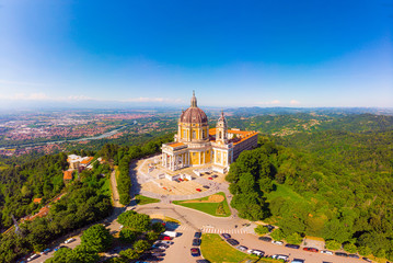 Beautifull aerial panoramic view to the famous from the drone Basilica of Superga in sunny summer day. The cathedral church located at the top of hill in italian Alps mountains. Turin, Piedmont, Italy