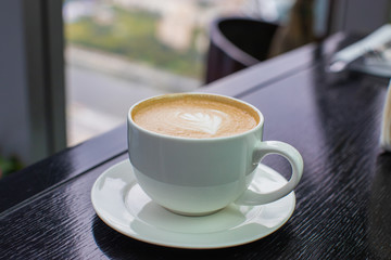 white Cup of cappuccino coffee with foam on the table in a cafe or restaurant