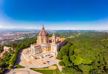 Beautifull aerial panoramic view to the famous from the drone Basilica of Superga in sunny summer day. The cathedral church located at the top of hill in italian Alps mountains. Turin, Piedmont, Italy - obrazy, fototapety, plakaty