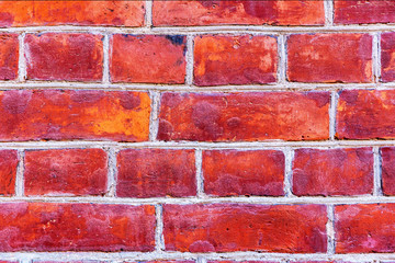Obraz premium a fragment of bright red with hints of a real brick wall. close-up. stone texture for text and design