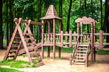 Wooden playground. Eco-friendly materials for children's play areas. Rest with the child in the park on a special area.