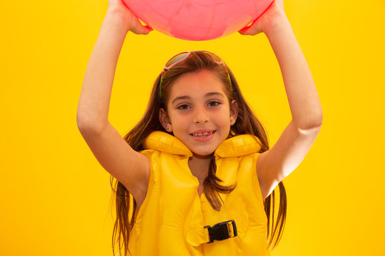 Child Wearing Life Jackets. On Yellow Background.