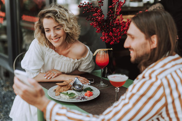 Beautiful young woman spending time with friend in outdoor cafe