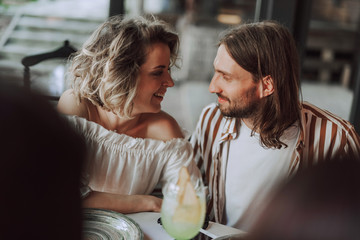 Beautiful couple sitting next to each other in cafe