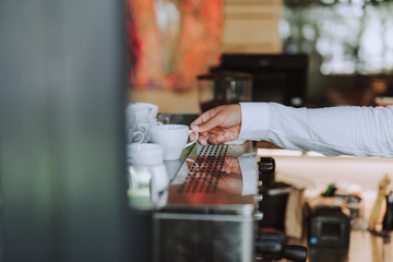 Young man taking white coffee cup in cafe