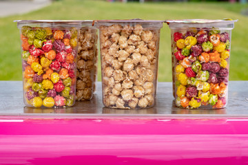 Full plastic transparent cup with popcorn in front of green background