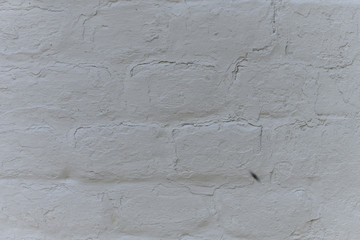 Old white roughly created brick wall painted with white paint, close up, copy space
