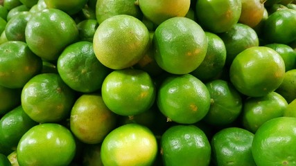 green lemon in market background, closeup view