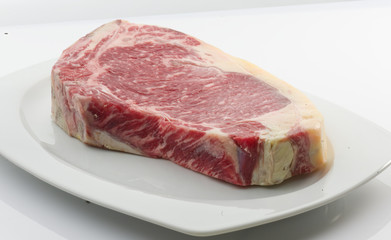 filete chuleton vaca sobre plato blanco. beef chuleton steak on white plate.