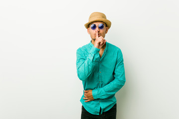 Young hispanic man wearing a summer clothes keeping a secret or asking for silence.